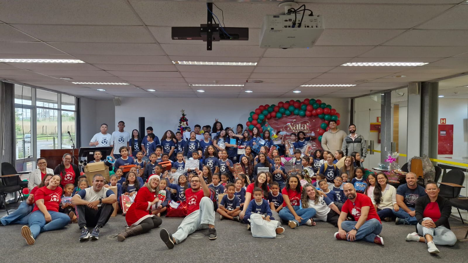 Crianças, adolescentes e equipe reunidos no Projeto Golfinho.
